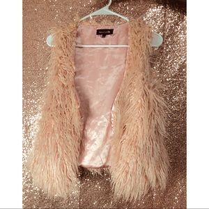 Light pink faux fur vest .